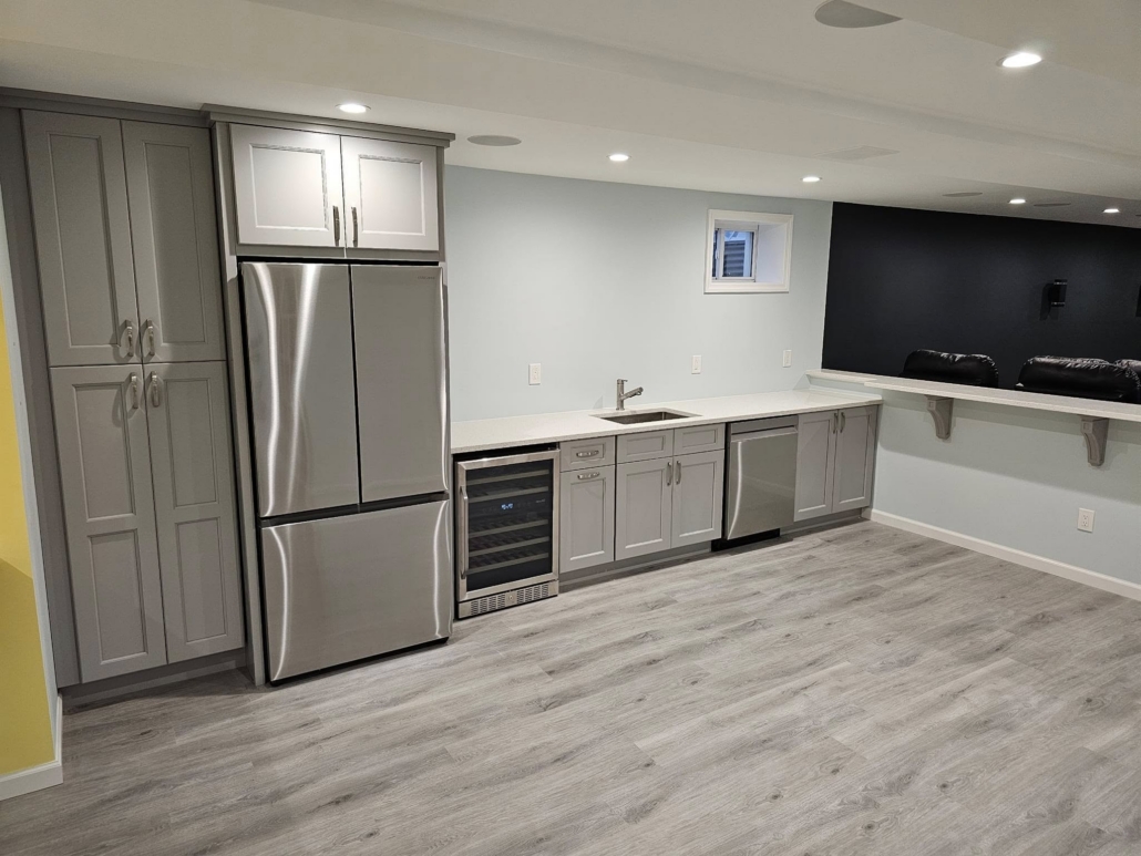 What is the 30% Rule for Home Remodeling in Suffolk County Finished basement in Suffolk County with a kitchenette, gray shaker cabinets, stainless refrigerator, wine fridge and bar counter
